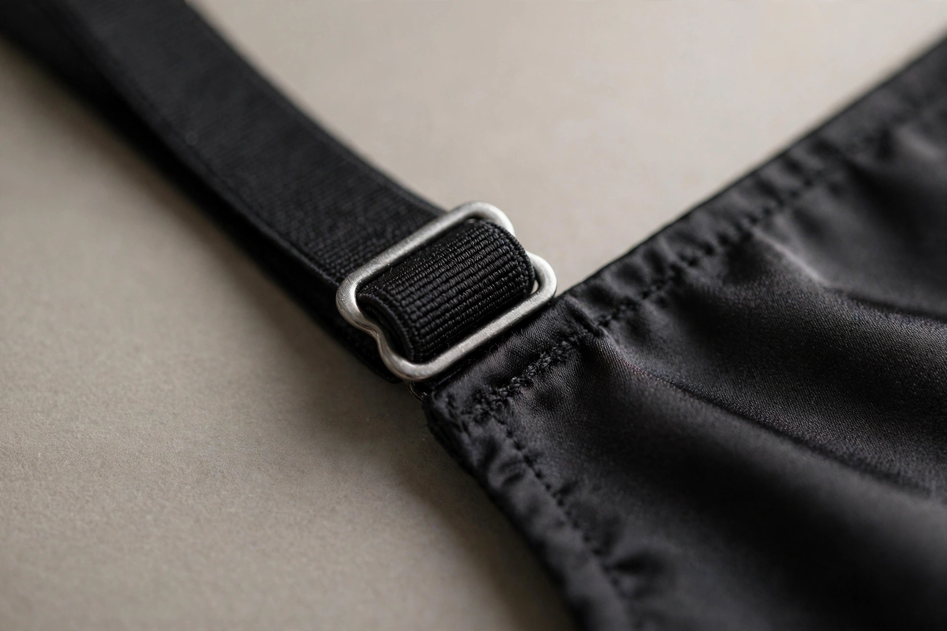Close-up of an adjustable strap slider on a bodysuit strap.