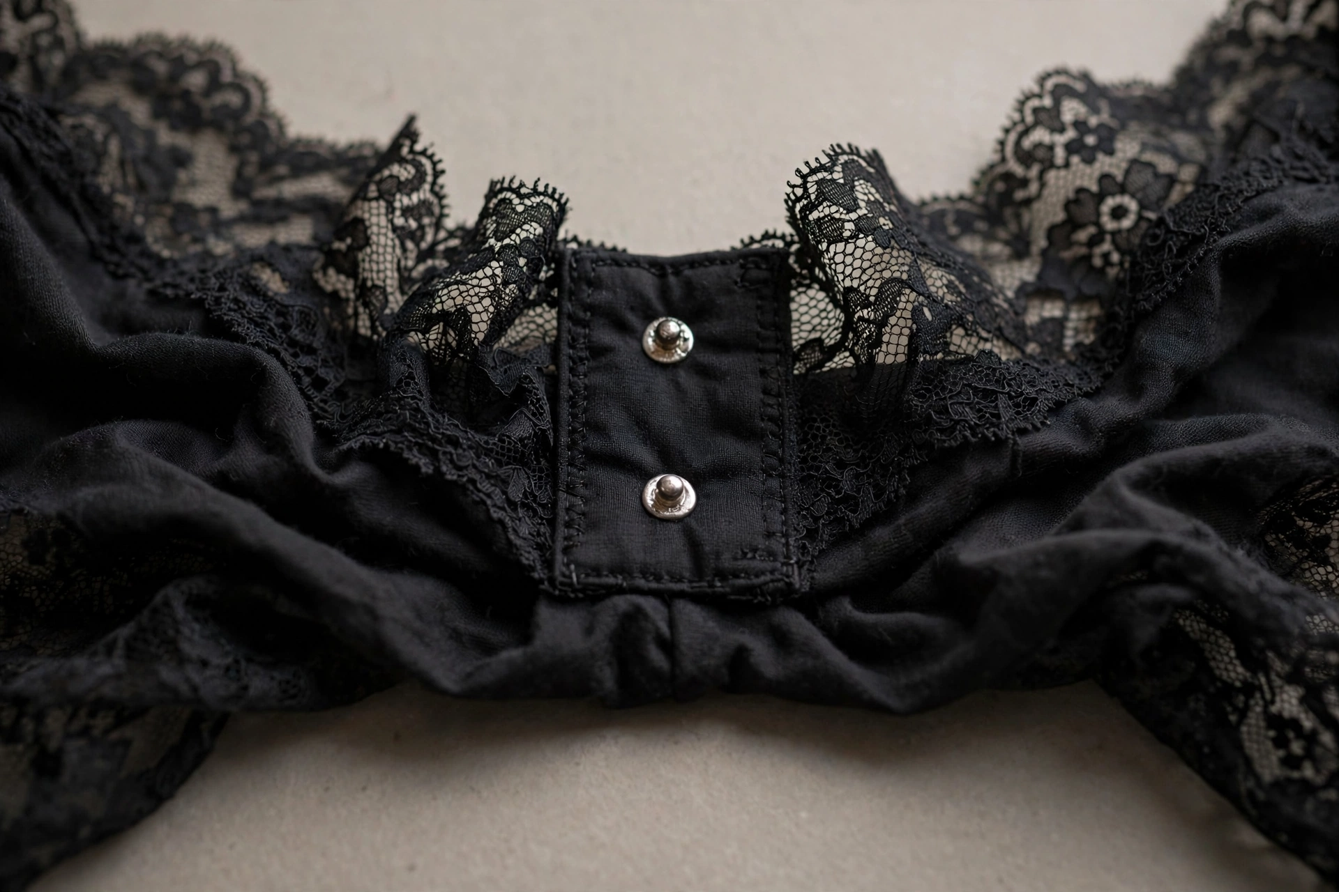 Close-up of a bodysuit gusset with a snap closure.